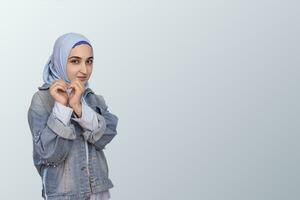 Young Arabian Muslim woman in hijab showing shape heart with hands. Religious, Islam, Positive human emotion expression, Love, Caring photo