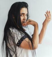 Portrait of charming middle-eastern woman. Side view of pretty beautiful female in white t-shirt photo