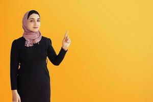 Portrait of stylish Iranian woman. Elegant Muslim woman in hijab pointing with hands to empty space. Copy space for your text. Beautiful Muslim female isolated photo