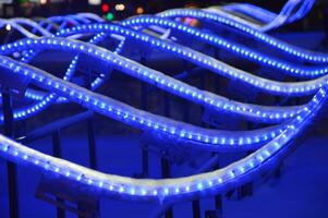 Glowing blue LED waves on a dark background. Element of Christmas light design of a city street at night. photo