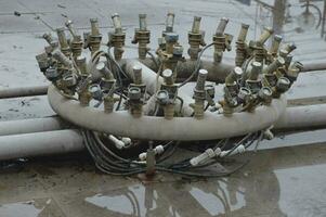 Pipes and communications of the fountain before the opening of the summer season in the park. Preparing to launch. The fountain is off. View of the underwater part of the turned off fountain. photo