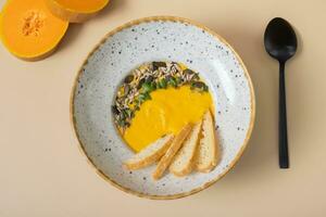 A plate of mashed pumpkin soup top view, flat lay. Autumn menu concept photo