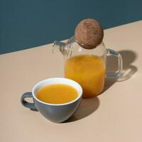 Cup and teapot of sea buckthorn tea. Minimalistic still life composition photo