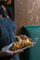 Canapes with shrimp chutney and mango on a plate in the hands of a waitress. Service area concept photo