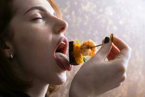 Shrimp and mango chutney canapes in female fingers near open mouth. Mini sandwich eating photo