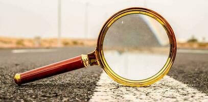 magnifying glass on the asphalt road photo