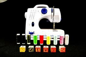 un de coser máquina con un variedad de diferente de colores hilo foto