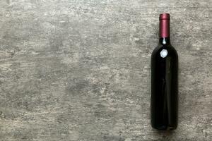 One Bottle of red wine on colored table. Flat lay, top view wth copy space photo