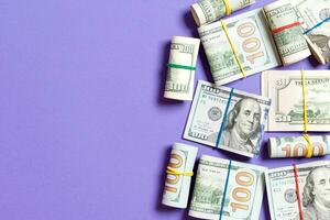 Stacks of one hundred dollars banknotes close-up on colored background business concept top view with copy space photo