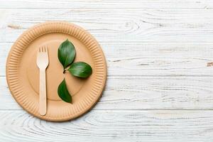 set of empty reusable disposable eco-friendly plates, cups, utensils on light white colored table background. top view. Biodegradable craft dishes. Recycling concept. Close-up photo