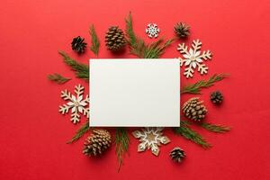 Flat lay Christmas composition. square Paper blank, pine tree branches, christmas decorations on Colored background. Top view, copy space for text photo