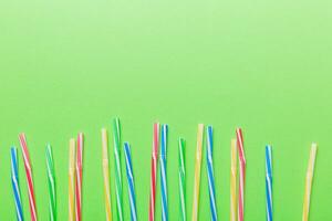 Heap of colorful plastic drinking straws on Colored background, flat lay. Copy Space for text photo