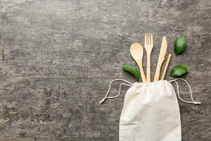 Eco friendly reusable recyclable white eco bag with kitchenware on Colored background. Concept zero waste photo