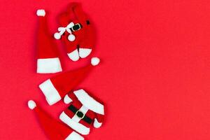 Top view of red Santa hats and clothes on colorful background. Merry Christmas concept with copy space photo