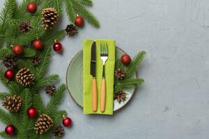 Christmas table place setting with christmas decor and plates, kine, fork and spoon. Christmas holiday background. Top view photo