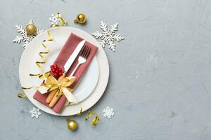 Christmas table place setting with christmas decor and plates, kine, fork and spoon. Christmas holiday background. Top view with copy space photo