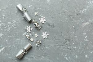 Christmas crackers with shiny confetti on color background, top view, copy space photo
