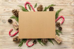 Flat lay Christmas composition. square Paper blank, pine tree branches, christmas decorations on Colored background. Top view, copy space for text photo
