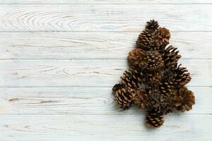 Christmas tree made from natural cones on colored background, view from above. New Year minimal concept with copy space photo