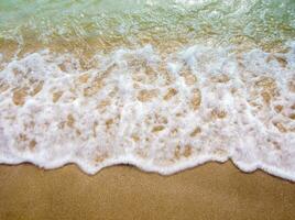 White bubble of Sea wave on the beach photo