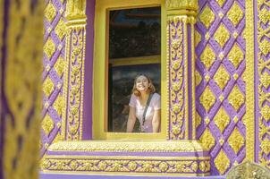 Asian Thai woman takes photo with purple church at Bang Chak Temple Nonthaburi Province