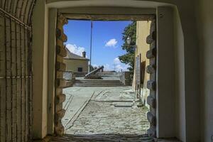 ver mediante un portón a el redondo bastión de el antiguo croata pueblo de laboratorio foto