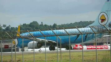 Phuket, Thailand November 27, 2015 filmisch Schuss, boeing 737 von nein Luft rollen auf das Runway beim Phuket Flughafen, Seite Sicht. asiatisch Verkehrsflugzeug hinter Flughafen Zaun. Flugplatz video