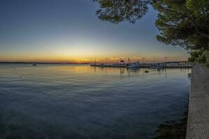 Sunset over the harbor of the Croatian port town of Fazana with a view of the Brijuni Islands photo