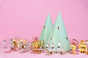 Party hats with the stars and festive decor on a pink background. Copy space. Close-up. photo