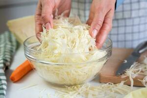 Woman's hands hold chopped cabbage. Dietary vitamin salad. Close-up. Selective focus. photo