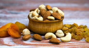 Mix of nuts and dried fruits on the wooden background. Healthy snack. Banner. Close-up. photo