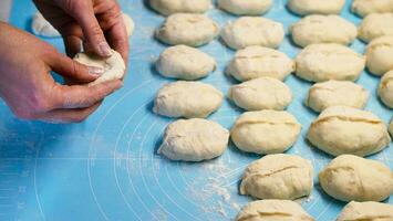 Woman's hands sculpt pie with potatoes and meat in the kitchen. The process of making homemade pies. Close-up. Selective focus. photo