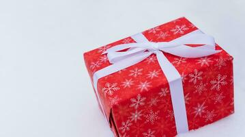 Christmas gift box on white snow. Close-up. Selective focus. photo