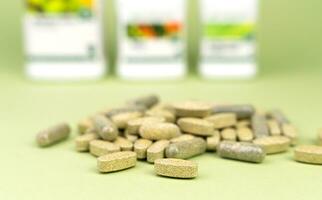 Natural vitamins and supplements on a green background. Close-up. Selective focus. photo