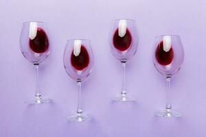 Many glasses of red wine at wine tasting. Concept of red wine on colored background. Top view, flat lay design photo