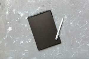 school notebook on a colored background, spiral black notepad on a table Top view photo