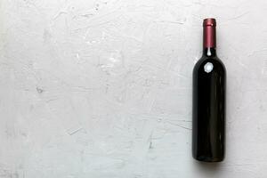 uno botella de rojo vino en de colores mesa. plano poner, parte superior ver con Copiar espacio foto