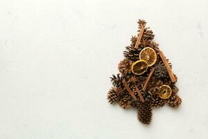 Christmas tree made from natural cones on colored background, view from above. New Year minimal concept with copy space photo