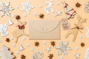 Festive decorations and toys on orange background. Top view of craft envelope. Merry Christmas concept photo