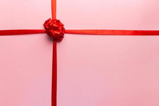 Top view of Red ribbon rolled and red bow isolated on colored background. Flat lay with copy space photo