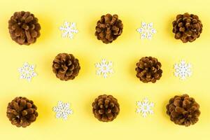 Top view of New Year ornament made of white snowflakes and pine cones on colorful background. Winter holiday concept with empty space for your design photo