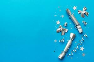 Christmas crackers with shiny confetti on color background, top view, copy space photo