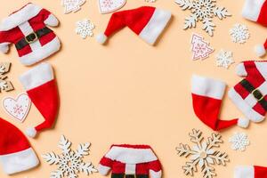 Top view of Christmas decorations and Santa hats on orange background. Happy holiday concept with copy space photo