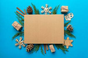 Flat lay Christmas composition. square Paper blank, pine tree branches, christmas decorations on Colored background. Top view, copy space for text photo