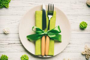 Holiday composition of Christmas dinner on wooden background. Top view of plate, utensil and festive decorations. New Year Advent concept photo