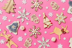 Top view of holiday decorations and toys on pink background. Christmas ornament concept photo