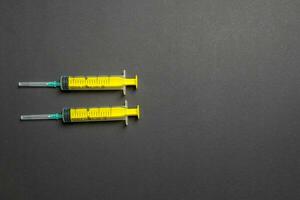 Top view of syringes in a row for medical injection on colorful background with copy space. Health and vaccination concept photo
