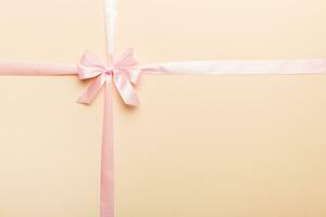 Top view of purple ribbon rolled and pink bow isolated on colored background. Flat lay with copy space photo