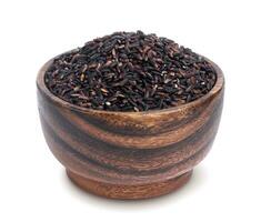 Black rice in wooden bowl isolated on white background photo