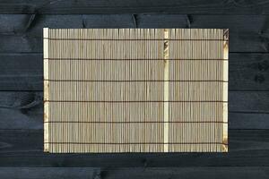 Bamboo mat on wooden table, top view photo